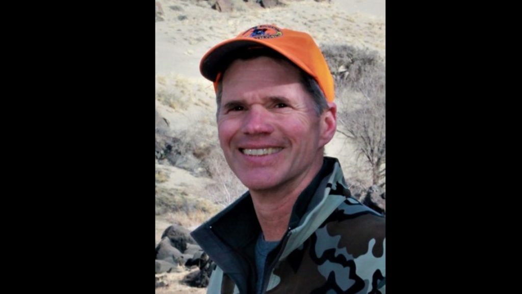 Photo of 2025-2026 WAFWA President, Jim Fredericks in hunter orange and camouflage.